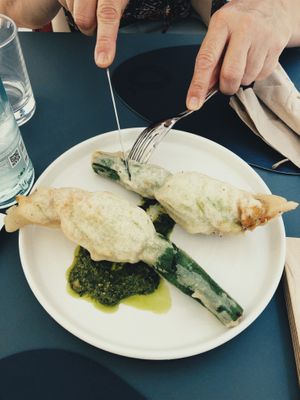 Fiori di zucchina in tempura ripieni di vegMozzarella di anacardo su pesto di basilico.  at Black Sheep Raw • Vegan Lab & Bistrot in Trento