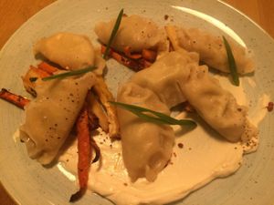 Tofu dumplings over ";vegetables"; (i.e.: carrots) with vegan sour cream at Veganic in Krakow