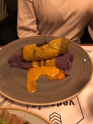 Stuffed cabbage leaf with red rice, boléus, dried tomatoes, zucchini, cheese sauce, truffles potato purée at Veganic in Krakow