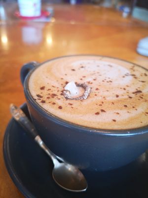 Picture of a grey cup and saucer containing a Dirty Mushroom Latte drink complete with mushroom decoration! at Planetwise & Yoga Studio in Bridlington