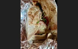 Inside the vegan tomtom wrap with seitan, homemade peanut butter, tartar spread, pickles, lettuce, tomato and vegan cheese. at Mayka in Belgrade