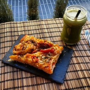 A piece of pizza with vegan mozzarella and 'chlorofil' juice! at Bioloco in Gran Canaria