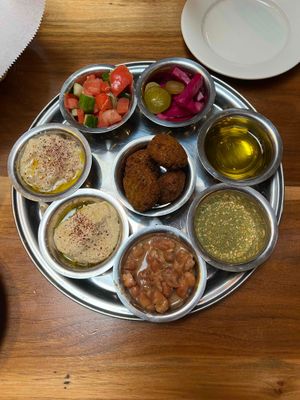 The amazing Futur Medley (all vegan). Counter-clockwise: Babaganoush, Hummus, Foule, Za'tar, EVOO, olives and (home made) pickles, cucumber-tomato salad, and falafel on center. at Ziatun in Beacon