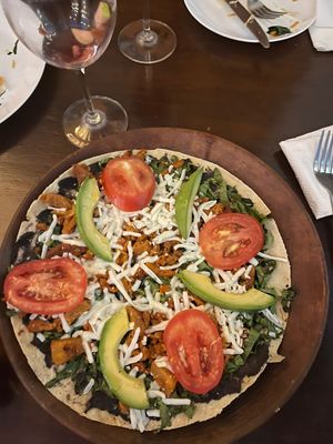 Tlayuda vegana: big corn tortilla with beans paste, lettuce, tomato, avocado, pastor seitan and vegan cheese at Le Campane in Oaxaca