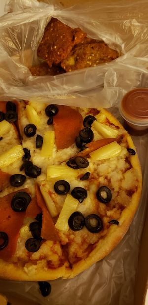 Three topping pizza and aliflowers at Akarma Vegan in Mexico City