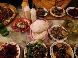 Full table with different dishes at Hummus in Delft