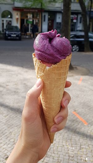 Vegan gelato. Cone filled with 3 flavors: blueberry yogurt, rhubarb-strawberry, pina colada at Balaram Eis in Berlin