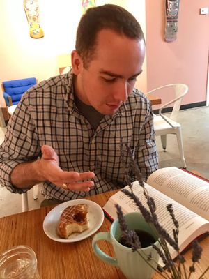 enjoying an espresso cream donut and drip coffee in the lobby area behind Holey Rollers at Holey Rollers Bakery in Oklahoma City