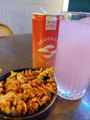 'Good Rays Raspberry & Guava' (£4.55) a CBD-infused sparkling drink, alongside a few crisps at Zizzi - The Strand in London