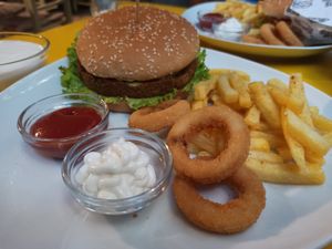 Cheeseburger meal with fries and onion rings, ketchup and mayo at Yasam Vegan Kafe in Izmir
