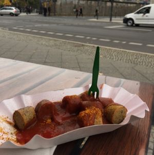 Vegan curry wurst with the wall in the background at Curry at the Wall - Food Stand in Berlin