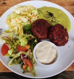 Beetroot cakes with garlic sauce and vegetables  at Faloviec Kuchnia Roślinna in Gdansk