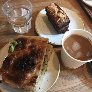 My brunch which filled me up until dinner (Avocado focaccia, chocolate and peanut slice, americano with oat milk and tap water)   at Pinkmans in Bristol