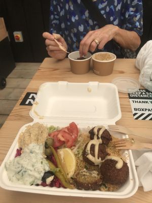 Mezze box (with half a falafel eaten) and falafel and hummus in pots  at What The Pitta in London