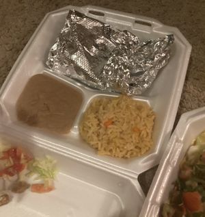 One unwrapped gordita, yummy rice and beans, and empty foil from gordita being eaten   at El Palote Panaderia in Dallas