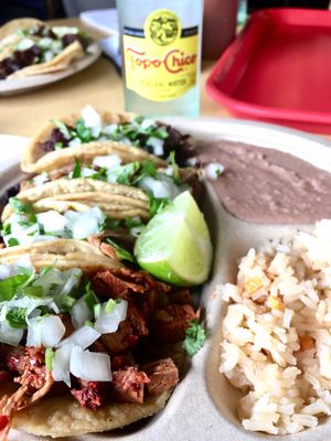 Four tacos, beans, and rice at El Palote Panaderia in Dallas