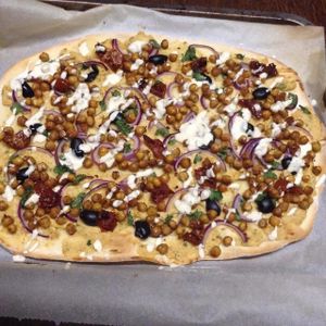 Our popular Vegan Pizza featuring Hummus, Roasted Chickpeas, Veggies,Olives & Garlic Dill Dressing at The Hidden Veggie Kitchen in Limoges