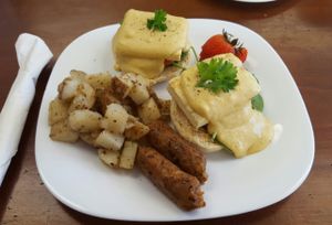 Tofu eggs benny on homemade biscuit, with a side of sausages. at Grow Your Roots Cafe in Ottawa