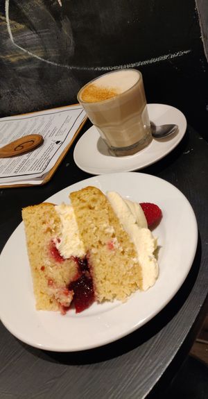 Almond and raspberry cake, with a chai latte.  at The Canvas: Shoreditch in East London