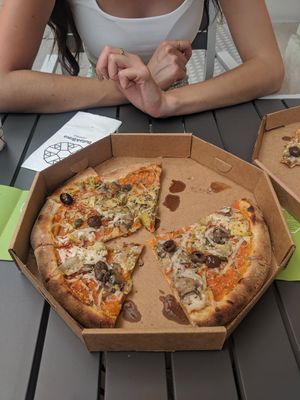 Vegan pizza with olives, capers, artichokes, vegan cheese and a marinara base and oregano topping at Bella&Brava in Venice