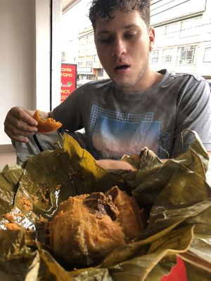 Adam eating a giant sized tamale  at La Campoteca in Bogota