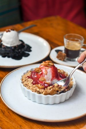 APPLE CRUMBLE | Caramelized apples, cinnamon, lemon zest, oat and almond crumble, strawberry sauce, Naveia vanilla ice cream, caramelized almonds. at Teva in Rio De Janeiro