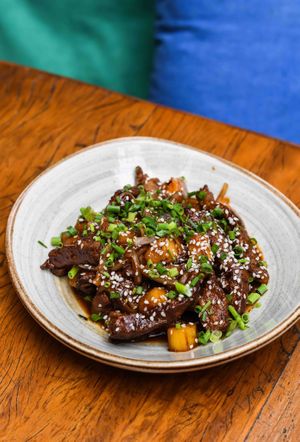 Crusted seitan dressed in sweet and sour korean pepper Gochujang sauce, caramelized onions and pineapple, sesame seeds, scallions. at Teva in Rio De Janeiro