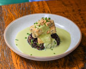 Black and white sesame seeds and rice crusted Uai tofu, black rice with garlic sprouts and bokchoy, edamame mint sauce, scallions, toasted peanuts. at Teva in Rio De Janeiro