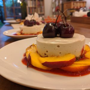 Vanilla cheesecake with berry coulis and baked peaches at Le Cheval Blanc  in Saint-antonin-noble-val