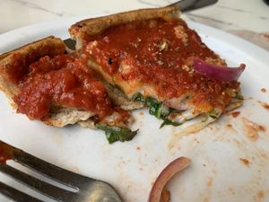 Topping under sauce, cheese onions spinach  at Patxi's Pizza in Santa Barbara