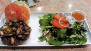 Vegan (Impossible) Build-A-Burger with side upgraded to a green salad. Fixings on burger were tomato, lettuce, Jalapeno, red onions, and sauteed mushrooms. About $15 plus. at Wild Flower Cafe in Red Hook