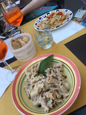 Pasta with creamy walnut sauce, fresh pea stuffed ravioli with tomato sauce. at In Pasta in Lucca