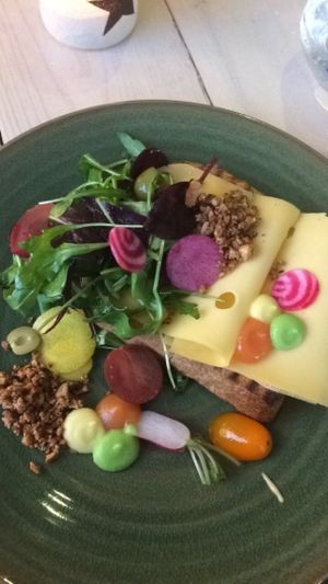 A delicious whole wheat piece of bread with cheese, greens and nuts. at Bij Albrecht in Eindhoven