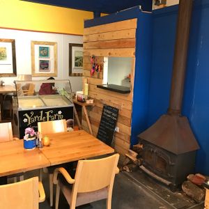 wood stove and local artwork on the walls at Wood and Green Cafe in Wadebridge
