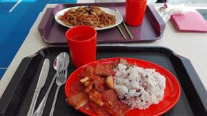 Smoked tofu in tomato sauce with five grains rice. In the back: spicy vegetable noodles.  at Vegether in New Territories