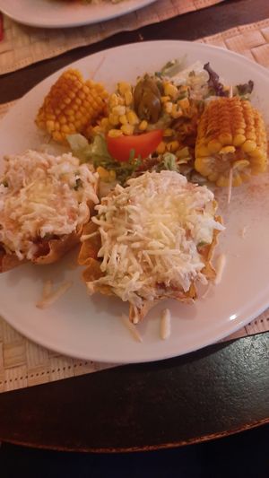 Hoofdgerecht: Tostada Toledo (?)  Gevuld met rijst, bonen, tomaat, avocado. Met vegan kaas, salade, guacamole, en maïskolven at Yucatan in Leeuwarden