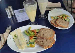 Un desayuno vegetariano y al fondo uno vegano con 2 tipos de zumos at Noah's Ark in La Gomera