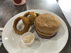 Double stacked burger - robust black bean pattie with lettuce tomato onion cucumber and aioli. Served on house bun with baked onion rings   at The Pureganic Cafe in Harrison