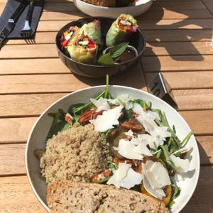 large veggie bowl salad with goat cheese, rice paper wrap and veggie burger in the back at Cafe Sage in Amsterdam
