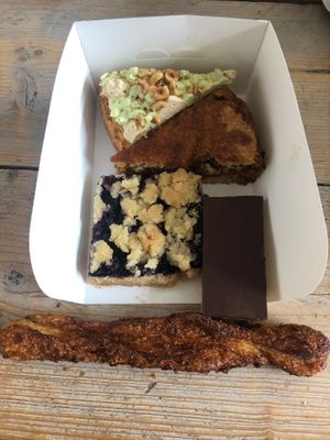 Assortment of different tarts and pies. All they sell is vegan. Here a pistachio cake, a chai cake, a blueberry crumble, a chocolate/caramel bar and a 'bolus' (local delicacy with sugar and cinnamon) stick.  at Fresco Middelburg in Middelburg