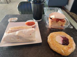 Burrito, latte, danish, and cinnamon roll at Black Hole Coffee House in Houston