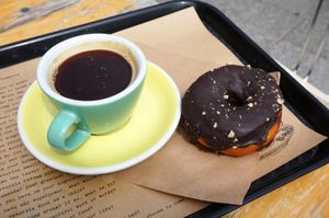 Café allongé + vegan chocolate donut at Shakespeare and Company Cafe in Paris
