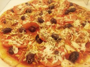 Specifically named vegan pizza, has olives, oregano, fresh tomato and vegan cheese at Allambie Pizza Shop in Allambie Heights