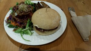 Burger de betteraves et haricots noirs servi avec salade et patates en quartier at Vegecafe Vertuose in Sherbrooke
