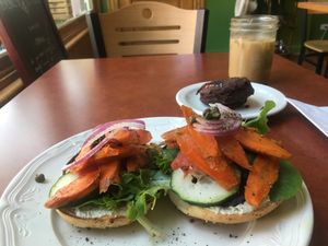 Cream cheese and smoked carrot lox bagel with chocolate donut and Breakfast Club latte w/oat milk at Fancy Plants Cafe in Chicago