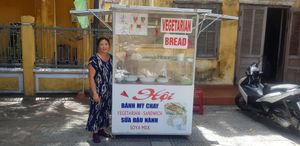 Shop and lady 
Hoi An old town, Nguyen Hue road, Trun Hung Dao at Hoi Banh My Chay - Food Stall in Hoi An