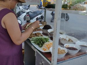 Owner preparing a banh mi at Hoi Banh My Chay - Food Stall in Hoi An