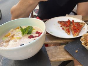 Vegan: Bowl with fruits, nuts and homemade almond milk. typical Mallorca tomato and onion cake  at Verdeteja in Mallorca
