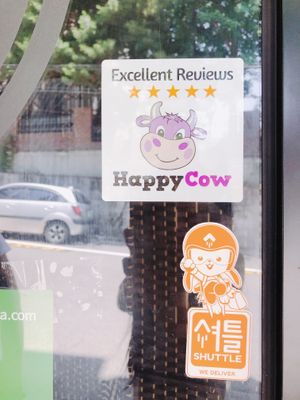 HappyCow Excellent Reviews sticker & Shuttle delivery sticker. 해피카우 스티커와 셔틀 딜리버리 서비스 스티커를 부착하고 있어요 at Sprout Korea Natural Whole Food Service in Seoul