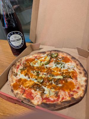 Pizza with vegan cheese, Daiya vegan sausage, artichoke, jalapeños and buffalo drizzle at Mod Pizza - 6th Ave in Seattle